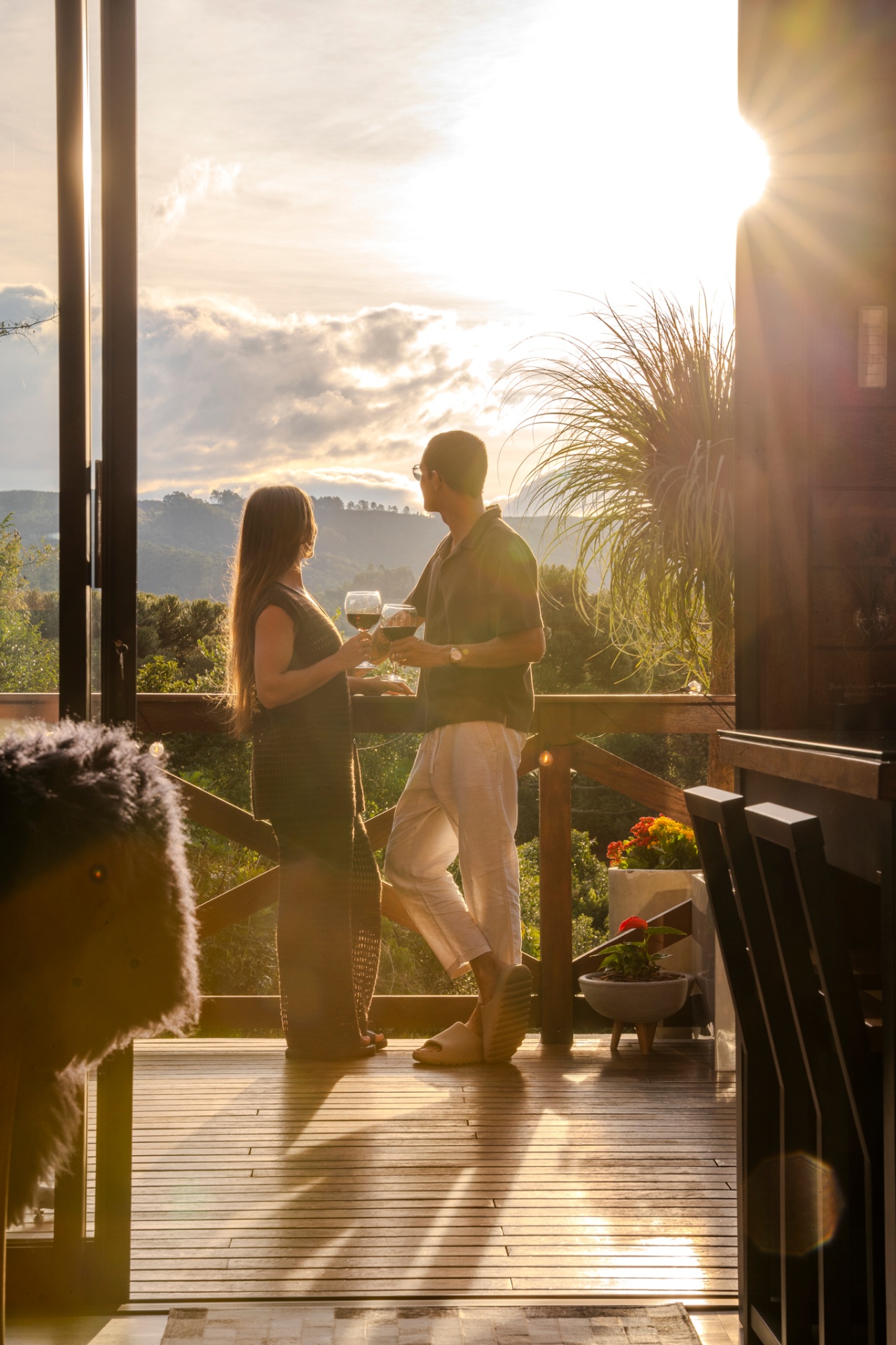 Casal brindando ao pôr do sol na varanda do Rancho Texel
