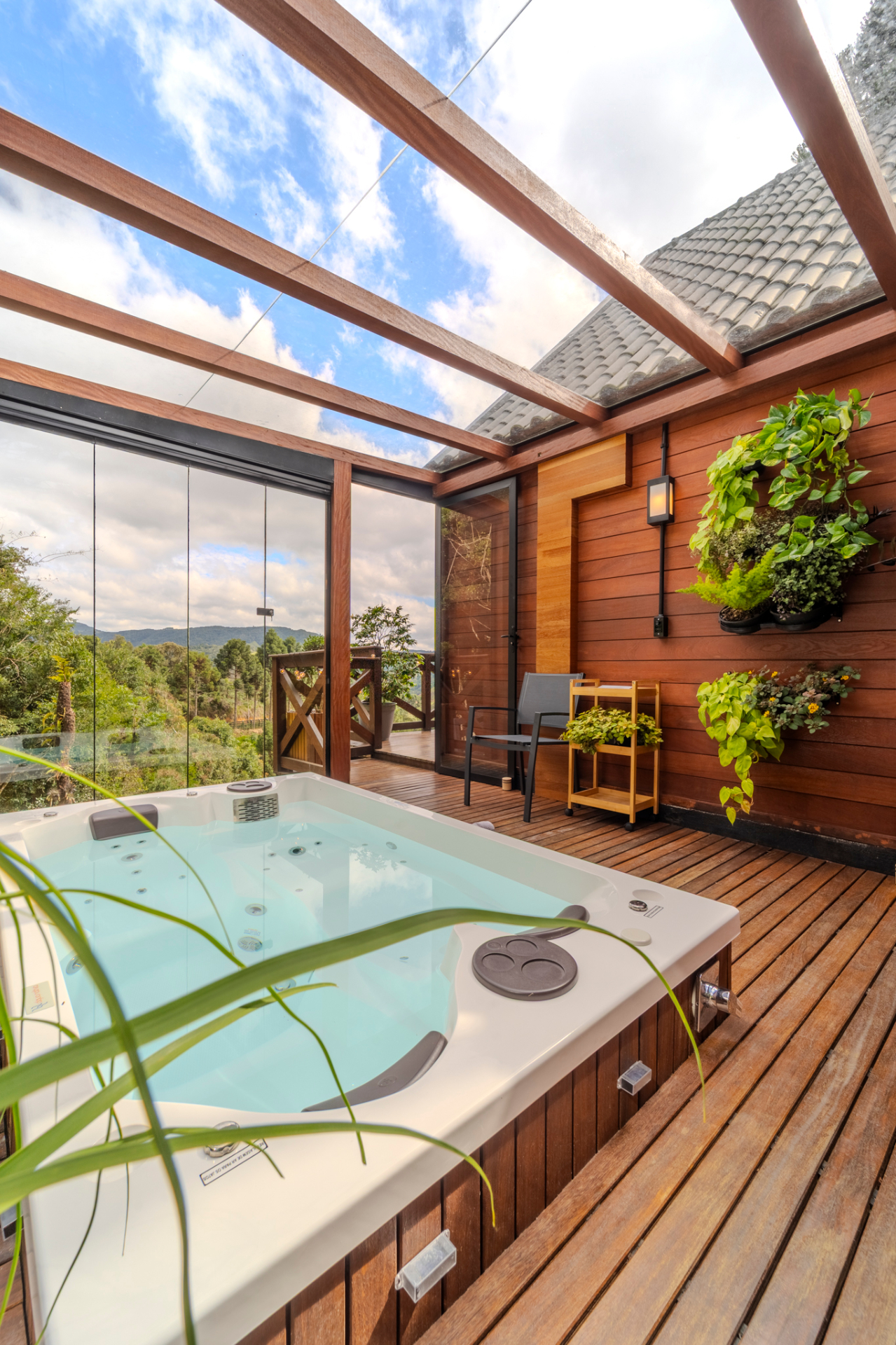 Jacuzzi sob teto de vidro com vista para a serra