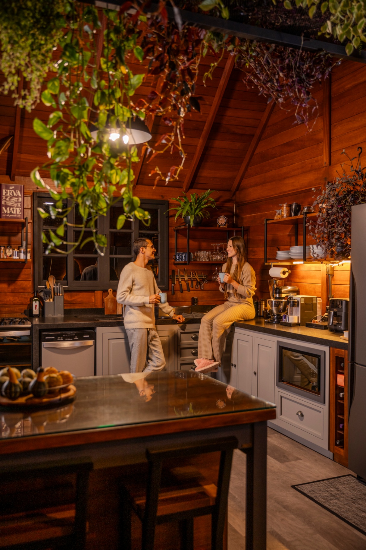 Cozinha gourmet com plantas e casal tomando café