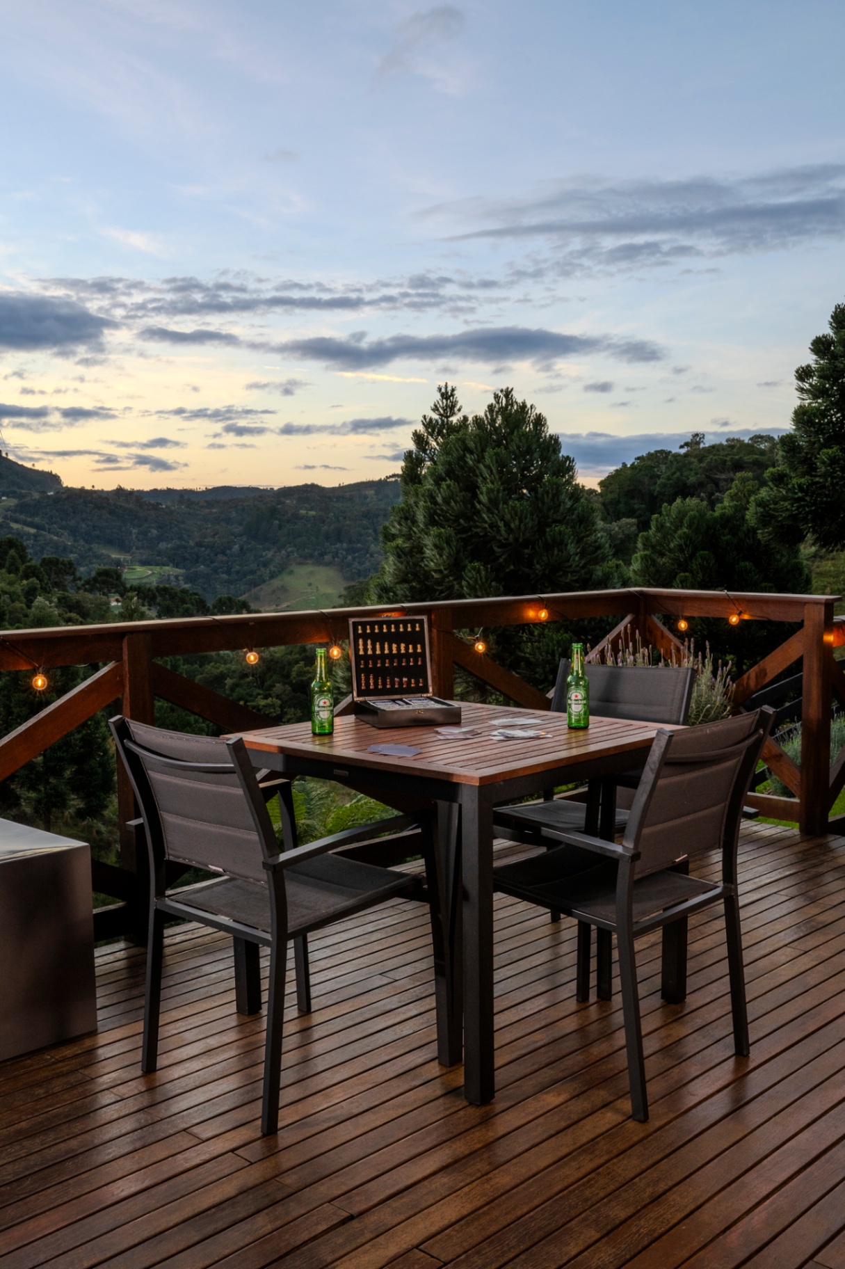 Mesa no deck ao entardecer com vista para o vale